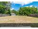 Large backyard featuring a green lawn, surrounded by mature trees and privacy fencing at 5193 Nw 61St Ave, Ocala, FL 34482