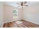 Well-lit bedroom featuring a ceiling fan and hardwood floors and a window overlooking the yard at 5193 Nw 61St Ave, Ocala, FL 34482