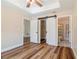Bedroom with barn door to closet and bathroom, modern ceiling fan, and wood floor at 5193 Nw 61St Ave, Ocala, FL 34482