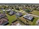 A sunny aerial shot shows homes with green lawns and streetscapes in a quiet neighborhood, providing serene community living at 5920 Sw 88Th Pl, Ocala, FL 34476