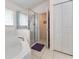 This bathroom features a tub and a glass shower with white tiled floors at 5920 Sw 88Th Pl, Ocala, FL 34476
