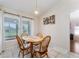 Cozy dining area with a wood table, chairs, and light-filled windows overlooking the yard at 5920 Sw 88Th Pl, Ocala, FL 34476