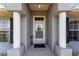 Close up of front entrance with white columns and decorative details that frame the entryway at 5920 Sw 88Th Pl, Ocala, FL 34476