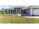 Inviting home featuring a well-manicured lawn, tidy landscaping, and an entrance adorned with white columns at 5920 Sw 88Th Pl, Ocala, FL 34476