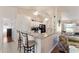 Well-lit eat-in kitchen with granite countertops, a breakfast bar, and white cabinets, adjacent to the living room at 5920 Sw 88Th Pl, Ocala, FL 34476