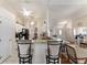 Open kitchen featuring a breakfast bar with seating, neutral granite countertops, and white cabinets at 5920 Sw 88Th Pl, Ocala, FL 34476