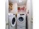 Convenient laundry room with modern, front-loading washer and dryer, plus built-in shelving for storage at 5920 Sw 88Th Pl, Ocala, FL 34476