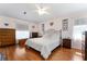 This main bedroom features a ceiling fan, wood floors, and large windows for natural light at 5920 Sw 88Th Pl, Ocala, FL 34476