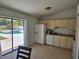 Kitchen with white appliances, light wood cabinets, and a sliding glass door leading to a pool at 6 Bahia Trace Loop, Ocala, FL 34472