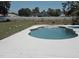 This backyard boasts a well-maintained in-ground pool and jacuzzi combo with a large white concrete patio at 6 Bahia Trace Loop, Ocala, FL 34472