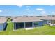 Backyard featuring patio, screened lanai and well maintained lawn with view of neighboring homes and blue sky at 6046 Sw 86Th Cir, Ocala, FL 34481