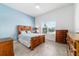Bright bedroom with natural light, wooden furniture, and light blue accent wall at 6046 Sw 86Th Cir, Ocala, FL 34481