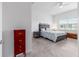 Bright bedroom features tile flooring, ceiling fan, and a comfortable bed with a decorative headboard at 6046 Sw 86Th Cir, Ocala, FL 34481