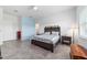Well-lit bedroom featuring tile floors, a ceiling fan, a bed with nightstands, and a light blue accent wall at 6046 Sw 86Th Cir, Ocala, FL 34481
