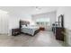 Well-lit bedroom featuring tile floors, a ceiling fan, a dresser, and a comfortable bed at 6046 Sw 86Th Cir, Ocala, FL 34481