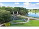 Community entrance with decorative water feature, lush landscaping, and stone accents at 6046 Sw 86Th Cir, Ocala, FL 34481