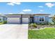Beautiful exterior showcasing a well-maintained lawn, a two-car garage, and attractive landscaping at 6046 Sw 86Th Cir, Ocala, FL 34481