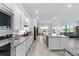 Bright, modern kitchen features white cabinetry, stainless steel appliances, and granite countertops at 6046 Sw 86Th Cir, Ocala, FL 34481