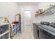 Well-equipped laundry room with modern washer and dryer, storage shelves, and utility sink at 6046 Sw 86Th Cir, Ocala, FL 34481