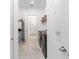 Functional laundry area featuring gray appliances, overhead storage and neutral flooring at 6046 Sw 86Th Cir, Ocala, FL 34481