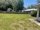View of the spacious, grassy backyard with mature trees and a wooden privacy fence at 6051 Ne 25Th Ave, Ocala, FL 34479