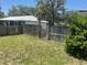 Wooden fence is featured with a wooden pergola and plentiful green grass at 6051 Ne 25Th Ave, Ocala, FL 34479