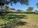 Spacious backyard with a wooden fence and mature trees is viewed on a sunny day at 6051 Ne 25Th Ave, Ocala, FL 34479