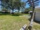 View of the grassy backyard with mature trees and a wooden privacy fence at 6051 Ne 25Th Ave, Ocala, FL 34479