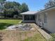 Large backyard with a grassy area and a covered area off the rear of the home at 6051 Ne 25Th Ave, Ocala, FL 34479