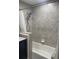Bathroom shower-tub combo featuring decorative gray tiles at 6051 Ne 25Th Ave, Ocala, FL 34479