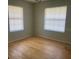 This bedroom has two windows and plywood flooring at 6051 Ne 25Th Ave, Ocala, FL 34479