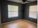 Bright bedroom with two windows and ceiling fan for ventilation at 6051 Ne 25Th Ave, Ocala, FL 34479