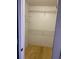 Empty closet with two shelves and plywood flooring at 6051 Ne 25Th Ave, Ocala, FL 34479