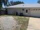 The rear exterior of home shows a garage, fenced yard, and utility area at 6051 Ne 25Th Ave, Ocala, FL 34479