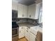 Bright kitchen featuring white cabinets, decorative backsplash and a large farmhouse style sink at 6051 Ne 25Th Ave, Ocala, FL 34479