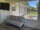 Enclosed patio with a grey futon, wood-look floors, and access to the backyard at 6051 Ne 25Th Ave, Ocala, FL 34479