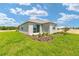 Well manicured backyard features an emerald lawn with mulch beds and grey exterior house at 7337 Sw 89Th Ter, Ocala, FL 34481