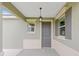 Inviting front porch with a stylish gray front door, lantern, and decorative shutters at 7337 Sw 89Th Ter, Ocala, FL 34481