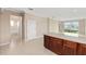Kitchen island with wood cabinets, granite countertop, and tile flooring in an open-concept layout at 7337 Sw 89Th Ter, Ocala, FL 34481