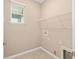 Bright laundry room features tile flooring, a window, and a wire shelf at 7337 Sw 89Th Ter, Ocala, FL 34481