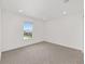 Well-lit bedroom with a window, neutral carpet, and white walls at 7624 Sw 60Th St, Ocala, FL 34474