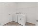 Well-lit laundry room with modern washer and dryer, practical storage shelves, and tiled flooring at 7624 Sw 60Th St, Ocala, FL 34474