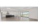 Bright, open-concept living room with tiled floors, modern kitchen, and sliding glass doors to the outdoor patio at 7624 Sw 60Th St, Ocala, FL 34474