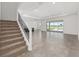 Spacious living room featuring tile flooring, a staircase, and sliding glass doors leading to the outdoor area at 7624 Sw 60Th St, Ocala, FL 34474