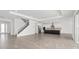 Spacious open-concept living room featuring staircase, tile flooring, and modern kitchen with stainless steel appliances at 7624 Sw 60Th St, Ocala, FL 34474