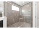 A walk-in shower with gray tiling, a glass enclosure, and a corner shelf at 7624 Sw 60Th St, Ocala, FL 34474