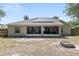 Home's back exterior shows screened in porch, solar panels, and a fire pit at 8053 Sw 62Nd Ave, Ocala, FL 34476