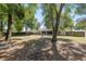 Spacious backyard featuring mature trees, a fire pit, and wood fencing at 8053 Sw 62Nd Ave, Ocala, FL 34476