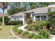 Well-kept home featuring a curved walkway, lush flowerbeds, and an arched window, with a neatly manicured lawn at 8053 Sw 62Nd Ave, Ocala, FL 34476