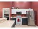 A well-lit kitchen features white and dark cabinets, stainless steel appliances, and a tiled floor at 8053 Sw 62Nd Ave, Ocala, FL 34476